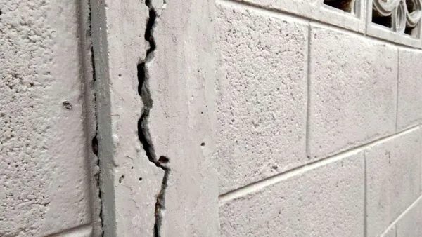 Stair-step crack pattern along mortar joints in a concrete block basement wall